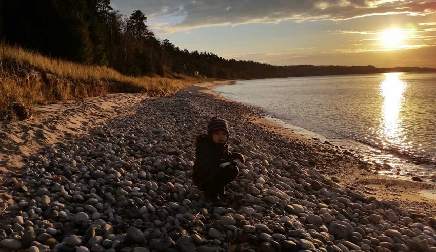 A young rock hound explores the beach near Cross Village (Photo: Jeremy Hammond)